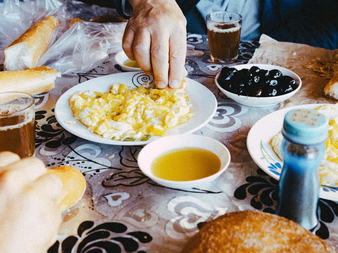 A traditional Moroccan breakfast in Fes with scrambled eggs, olives, bread, and tea.